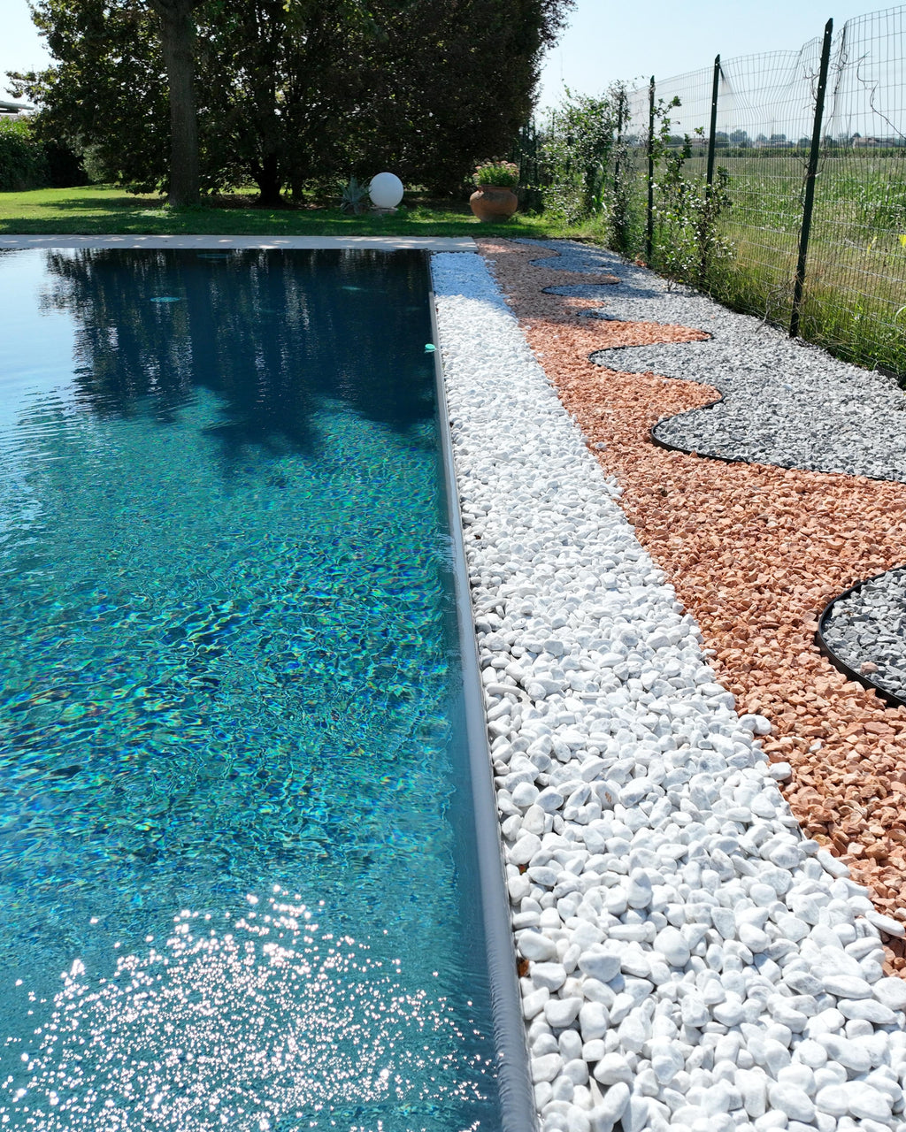 Piscina a sfioro con sfioro con sassi drenanti soluzioni per piscina Zavatti Piscine