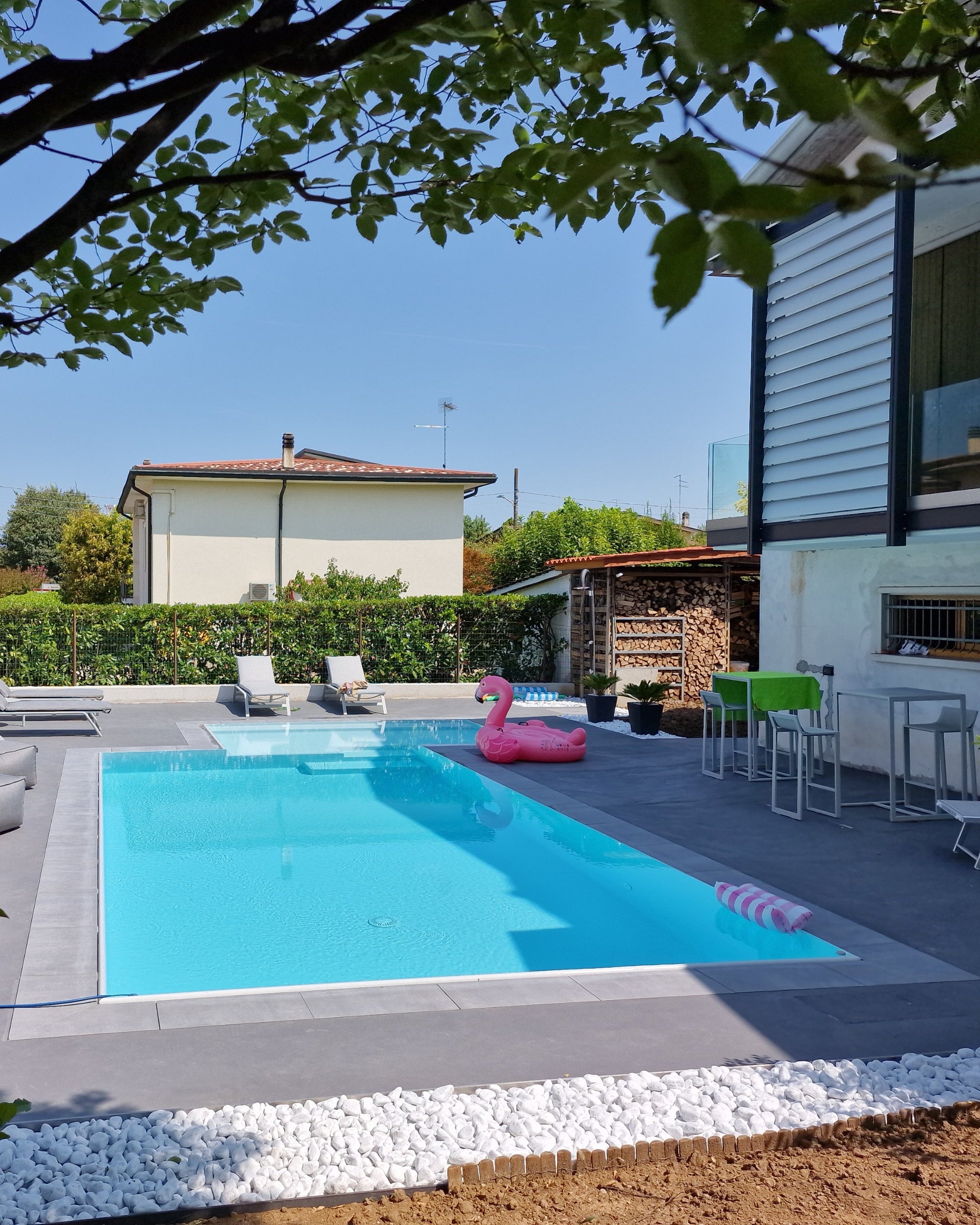 Piscina a sfioro con spiaggia angolare esterna