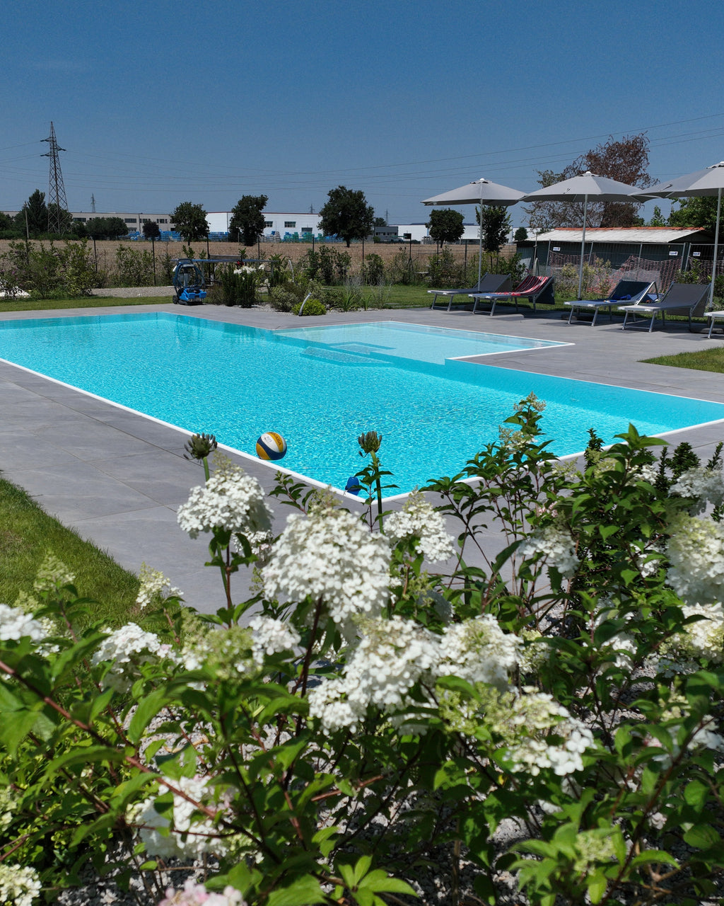 Piscina a sfioro senza vasca di compenso con spiaggia centrale semiesterna Zavatti Piscine a sfioro