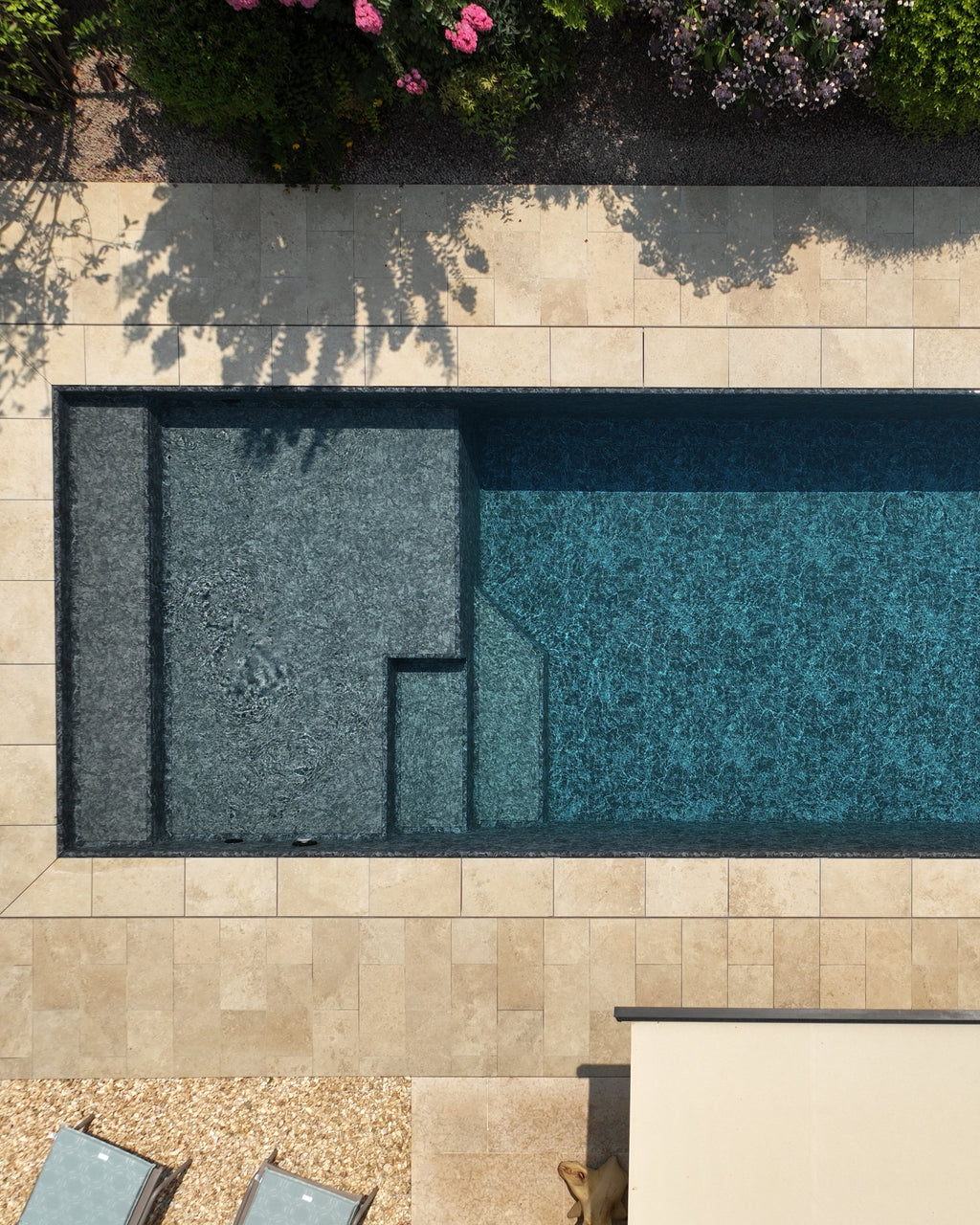 Piscina sfioro con spiaggia a tutta larghezza rivestimento nero marmorizzato