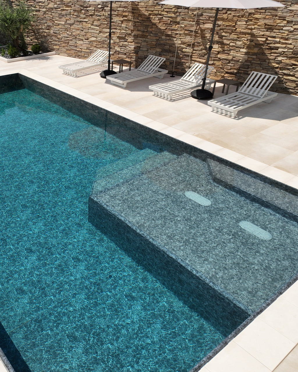 Zavatti piscine, piscina a sfioro senza vasca di compenso con spiaggia angolare e zona idromassaggio